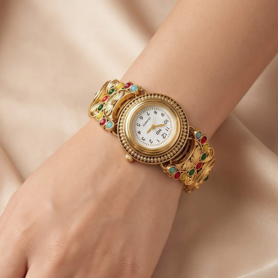 A close-up of a vintage-style gold watch with colorful enamel details, worn on a woman's wrist against a soft beige satin background.