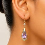 Teardrop-shaped earring with purple gemstone worn by a person