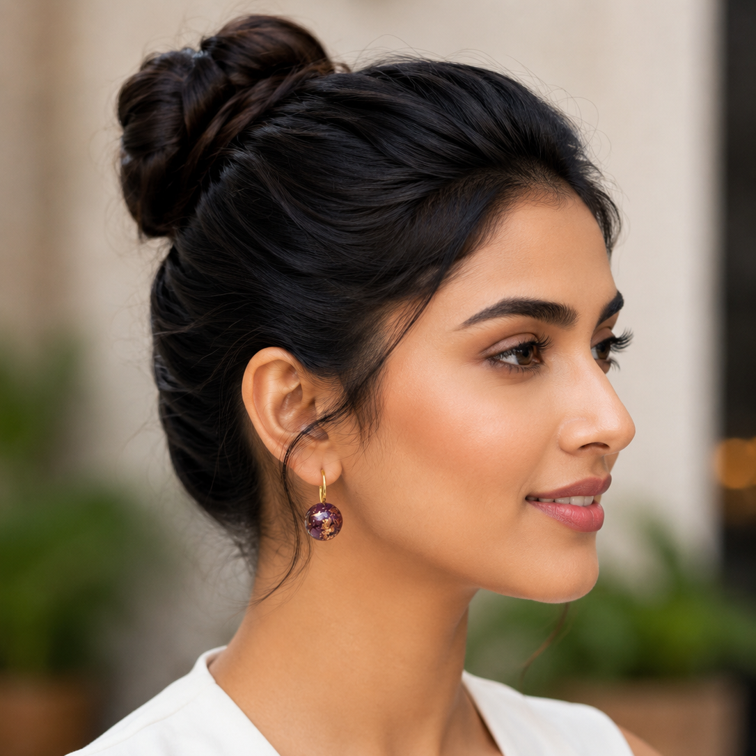Woman with styled hair and earrings in an outdoor setting