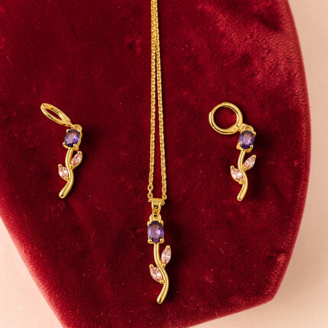 Gold tone necklace with purple stones on a red velvet cushion