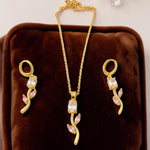 Gold  tone jewelry set with necklace and earrings on a brown velvet cushion