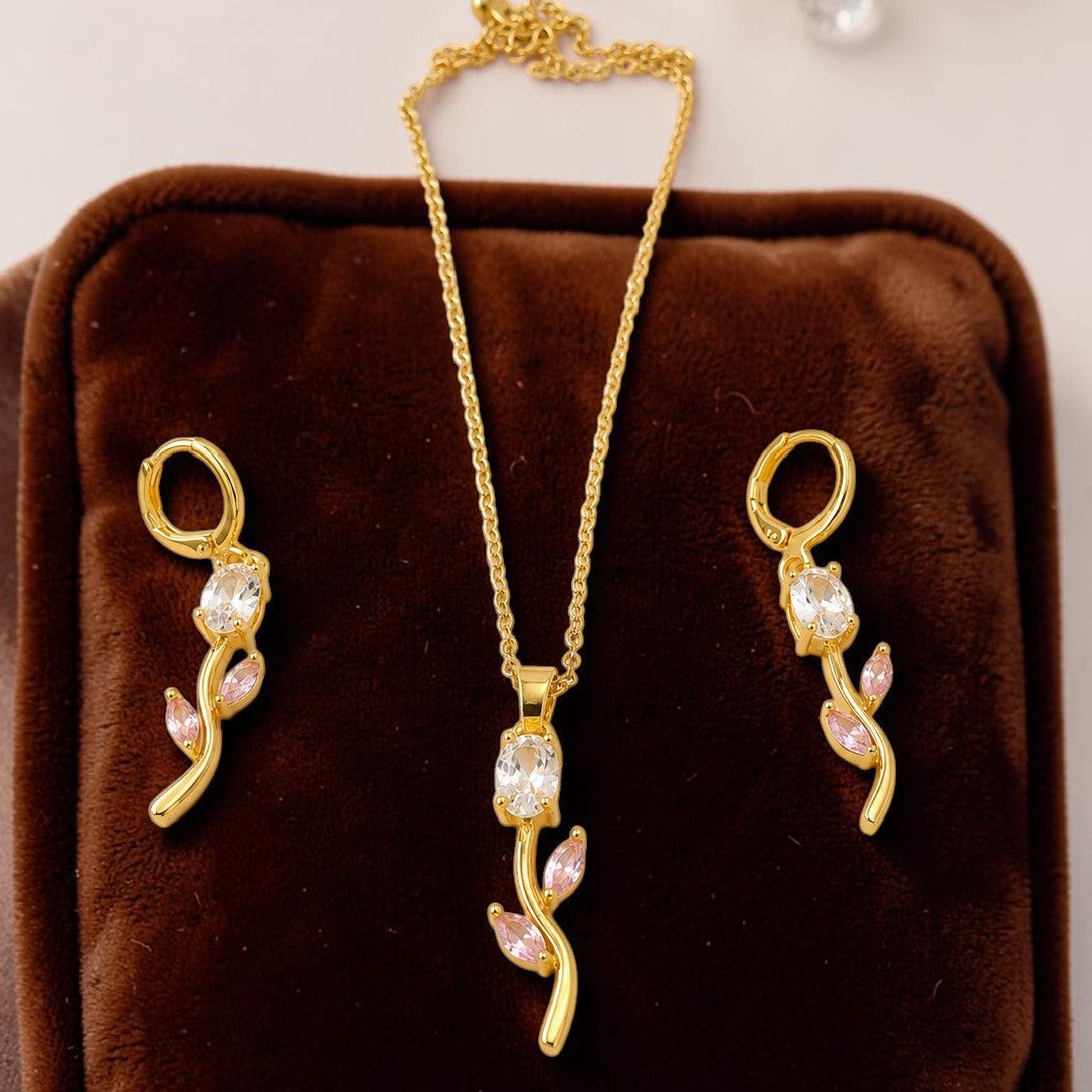 Gold  tone jewelry set with necklace and earrings on a brown velvet cushion