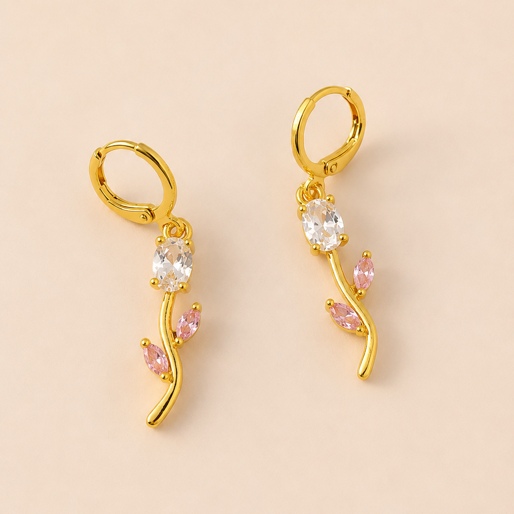 Gold  tone earrings with gemstones on a beige background