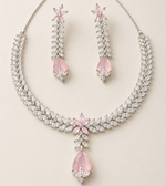 Necklace and earrings set with pink teardrop stones on a light background