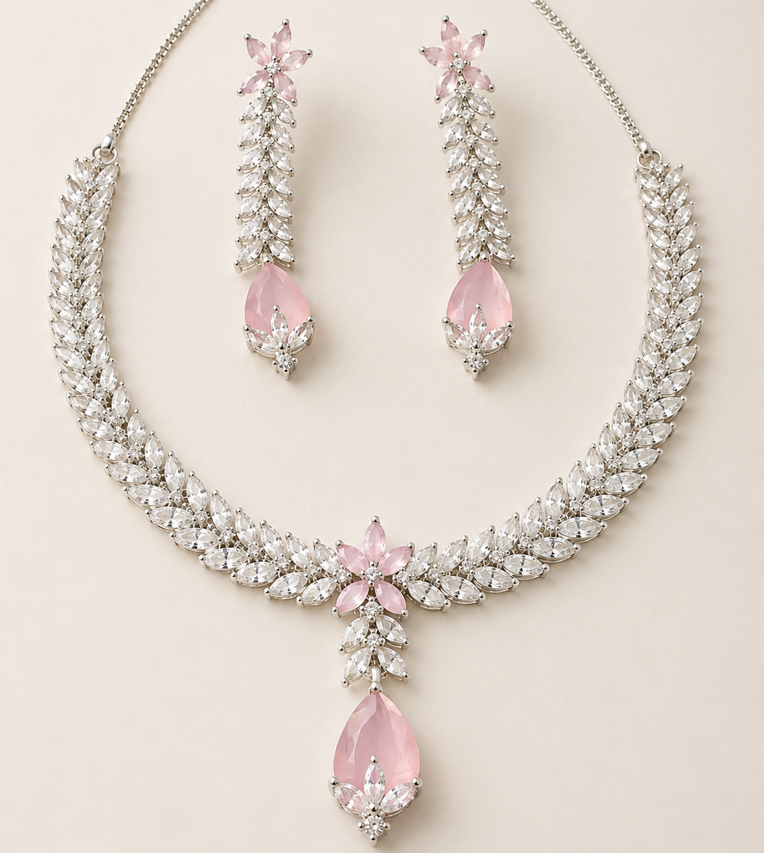 Necklace and earrings set with pink teardrop stones on a light background