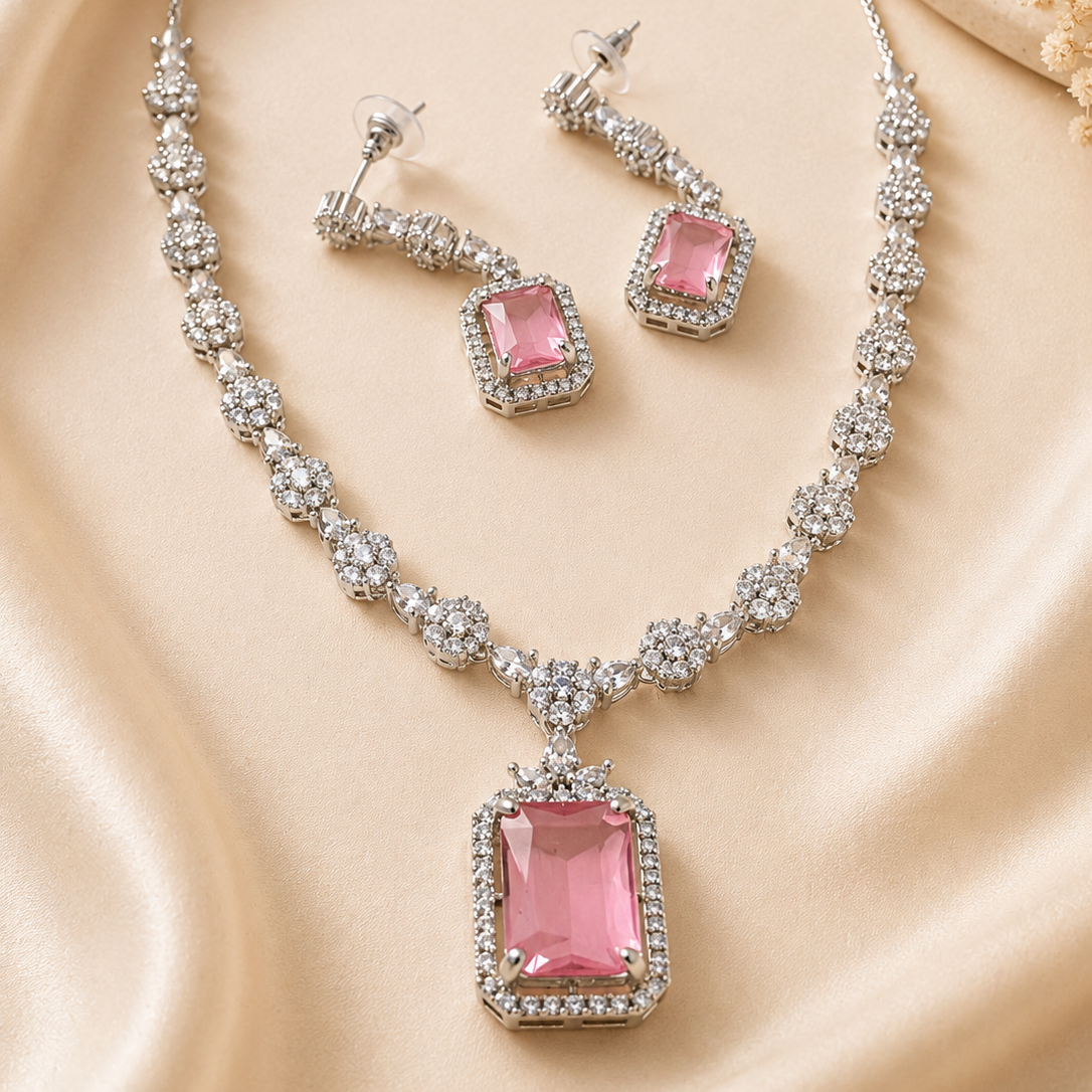 Jewelry set with pink gemstones on a beige fabric background