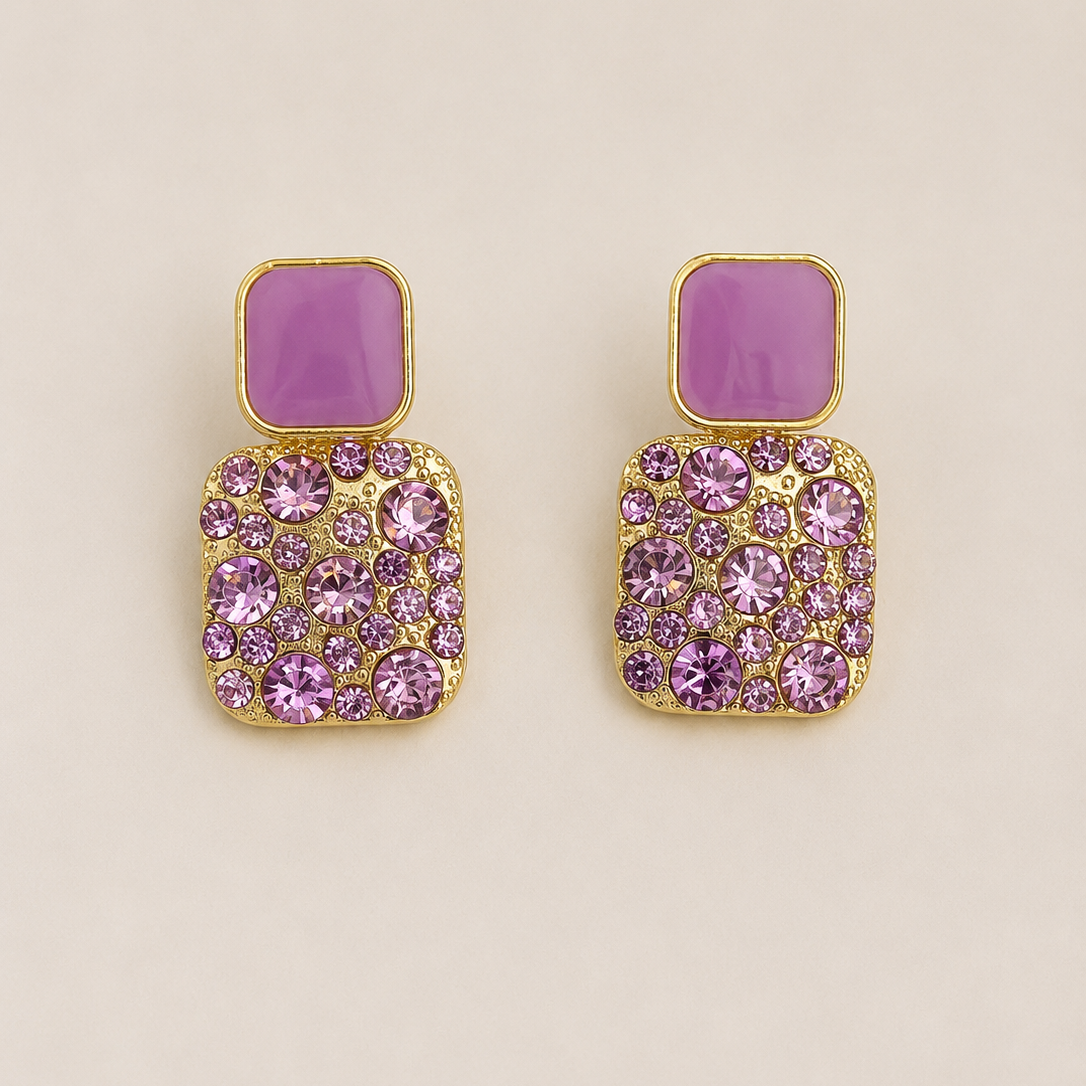 Pair of earrings with purple gemstones on a beige background