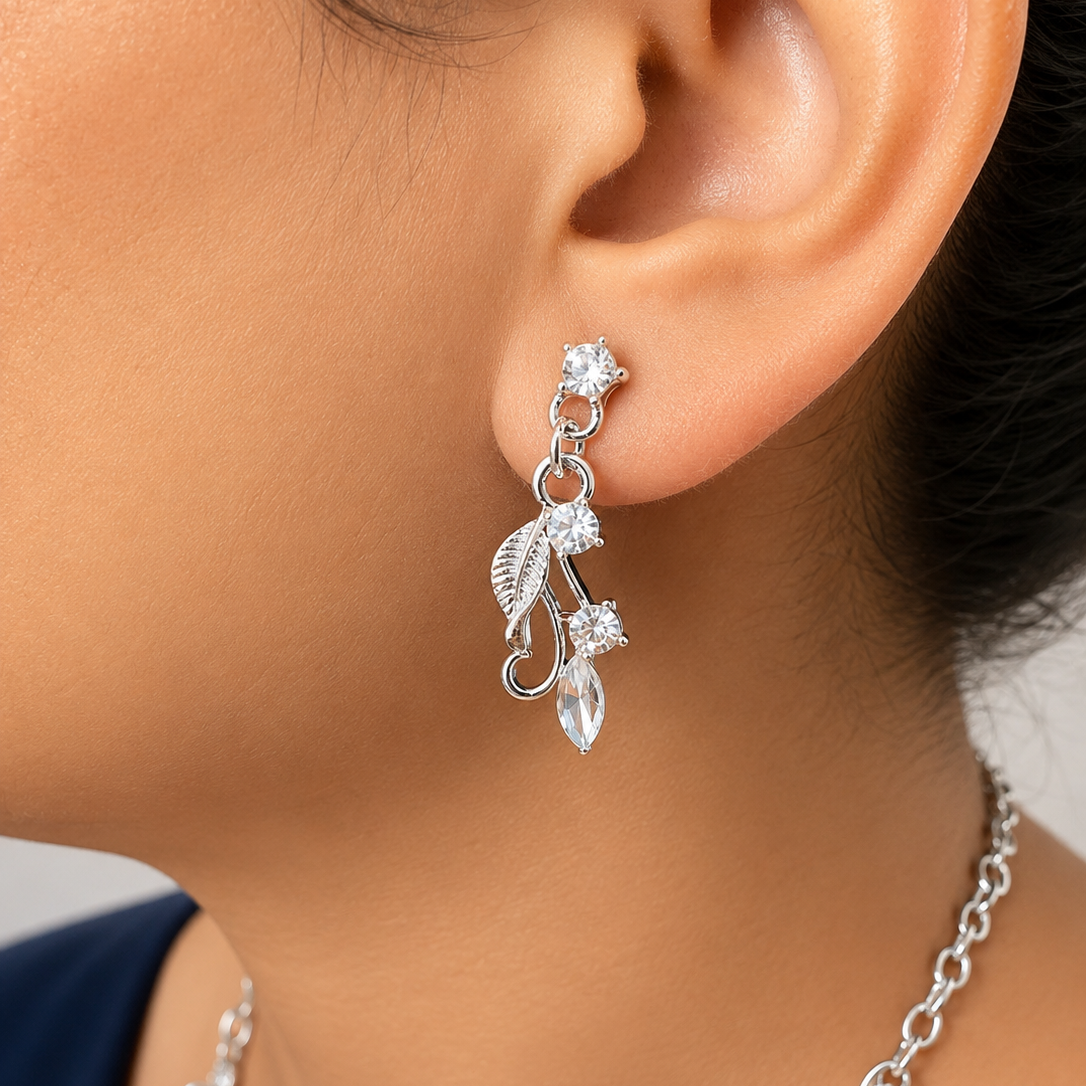 Silver leaf earrings worn by a person with a blurred background