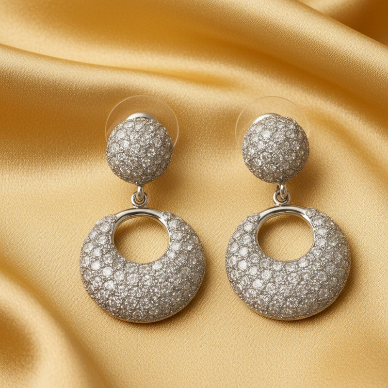 Silver tonre earrings with circular designs on a gold satin background
