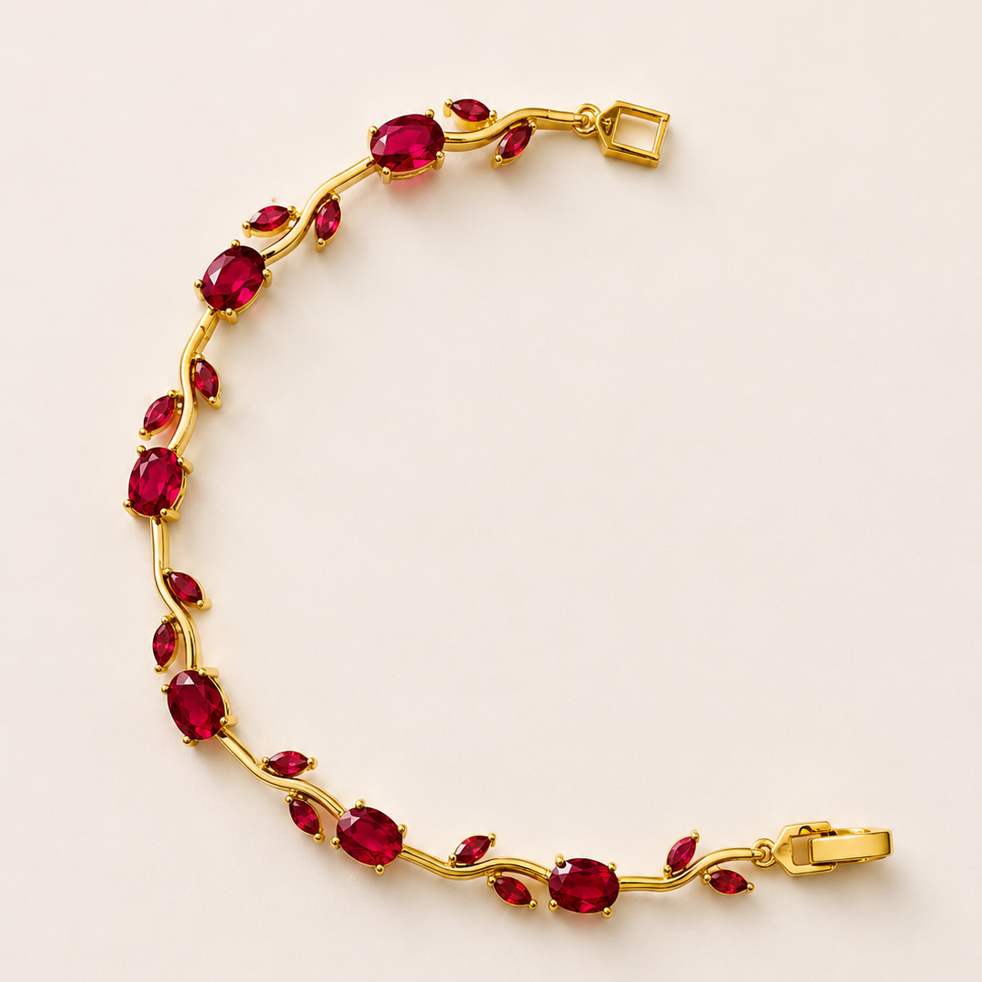 Gold tone bracelet with red gemstones on a beige background