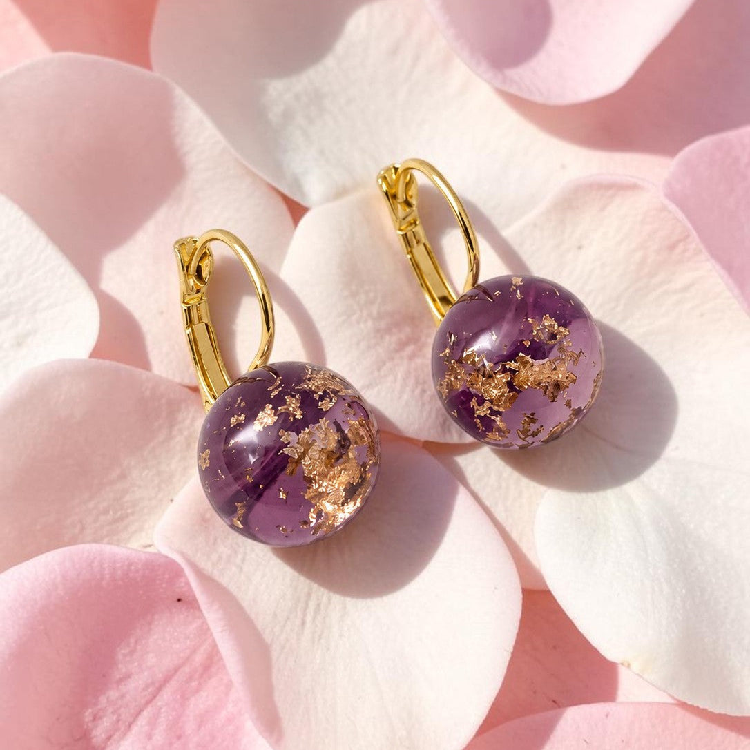 Purple earrings with gold accents on pink petals