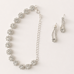Silver necklace and earrings set on a white background