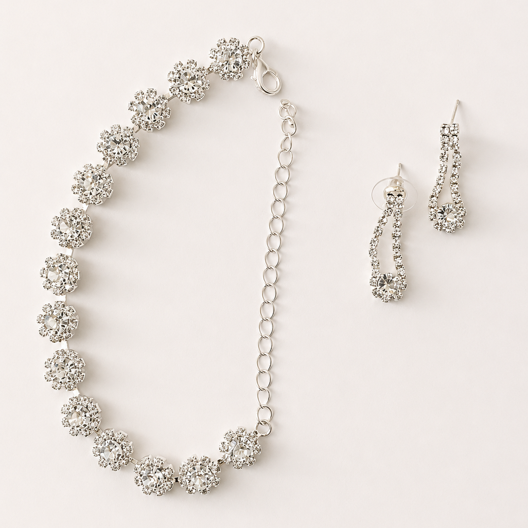 Silver necklace and earrings set on a white background