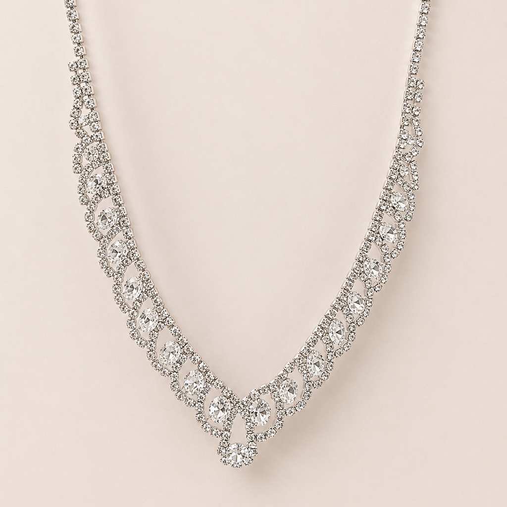 Silver necklace with clear stones on a light pink background