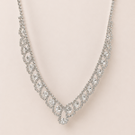 Silver necklace with clear stones on a light pink background