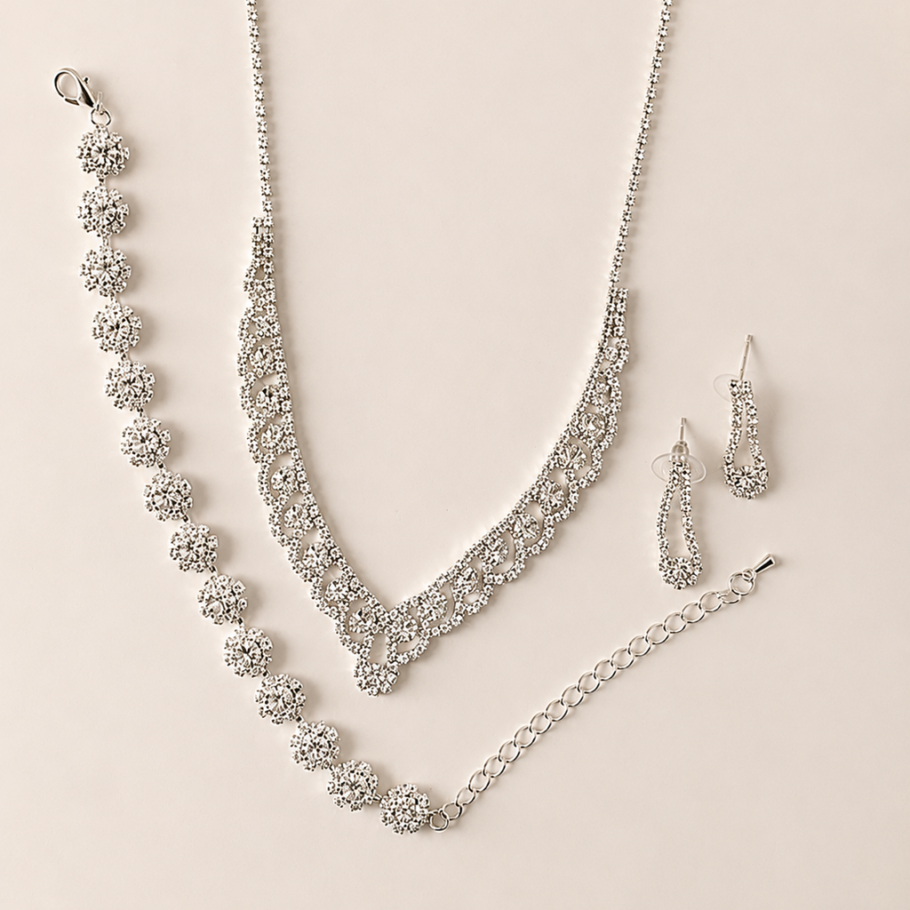 Silver jewelry set with necklace, bracelet, and earrings on a beige background