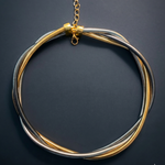 Necklace with gold and silver strands on a dark background