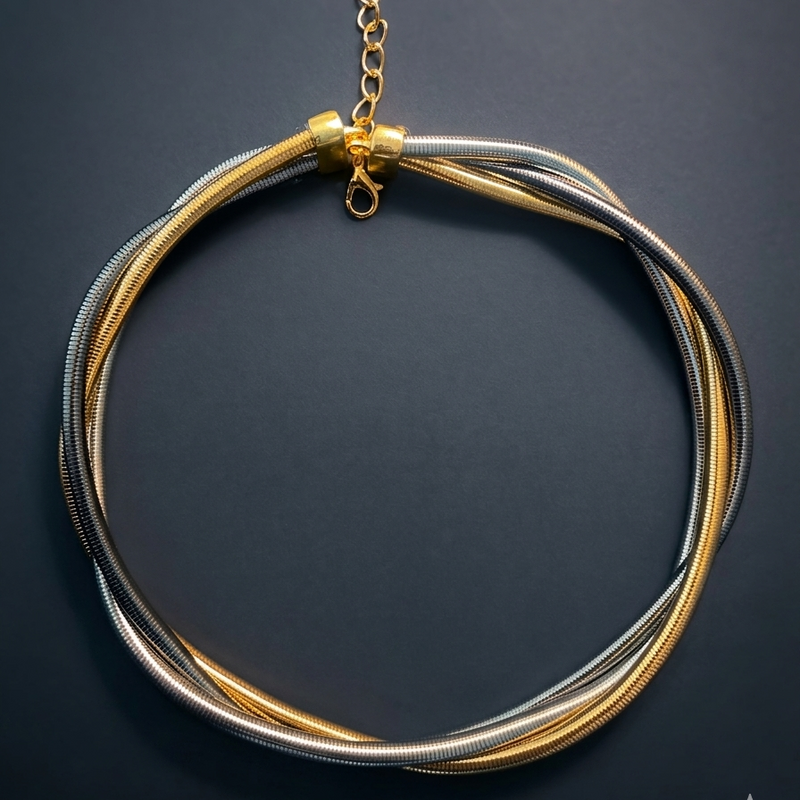 Necklace with gold and silver strands on a dark background