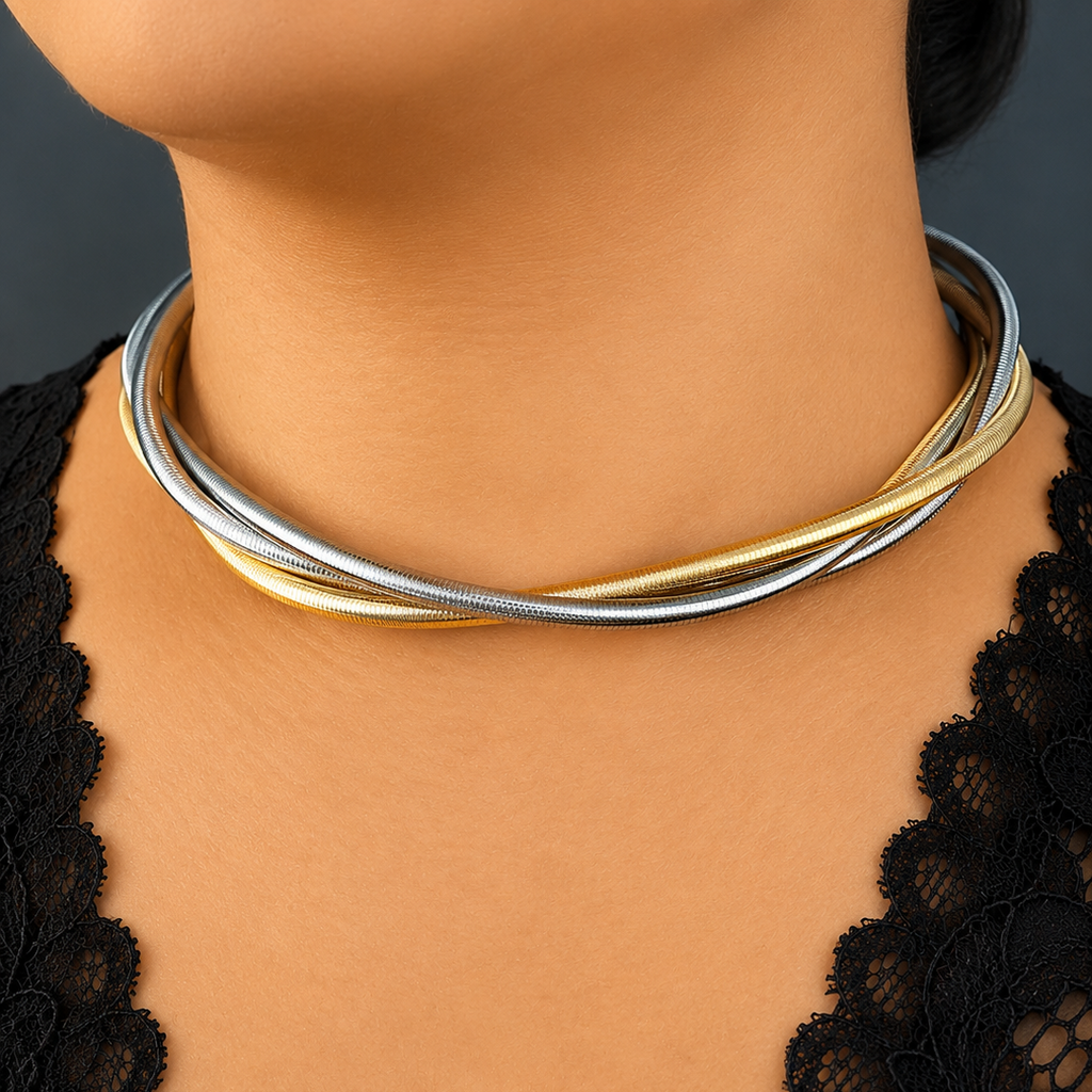 Close-up of a person wearing a gold and silver necklace against a dark background
