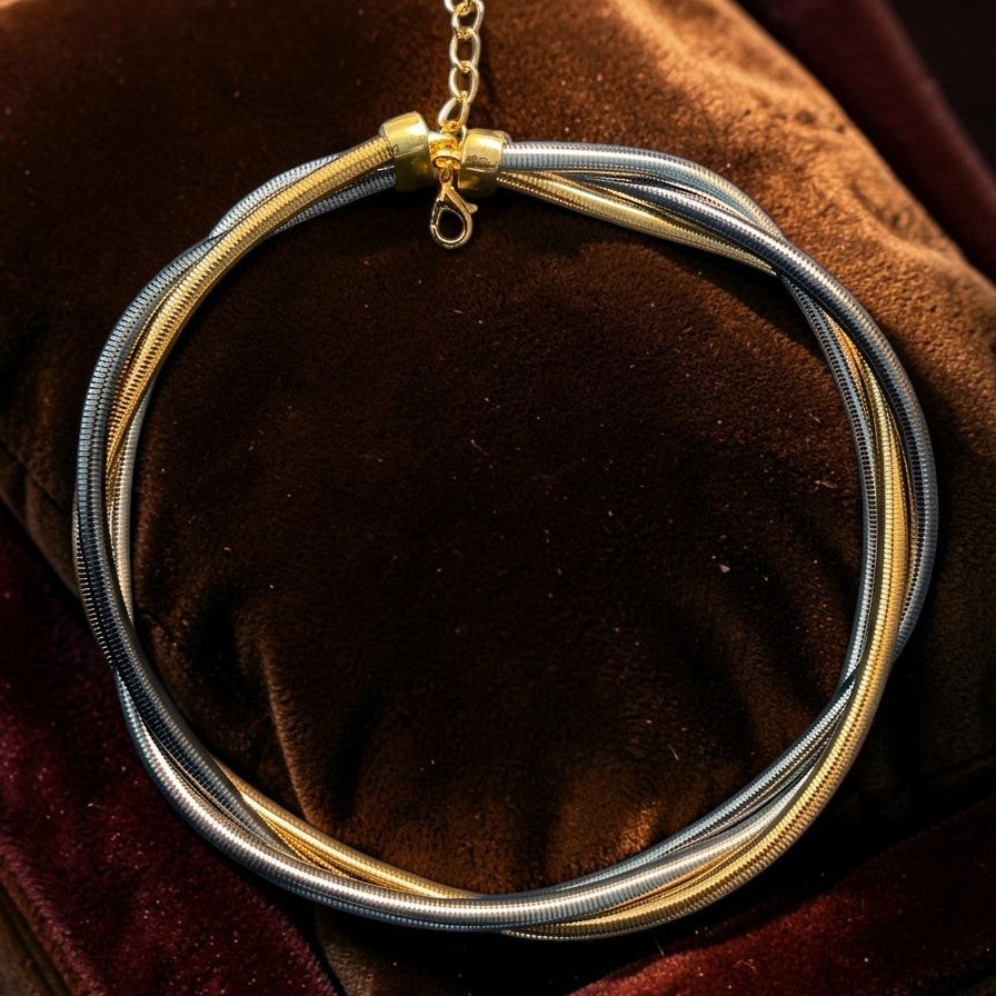 Necklace with gold and silver circular pendants on a brown velvet surface