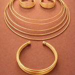 Set of gold tone necklaces on a brown background