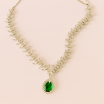 Necklace with a green gemstone pendant on a light pink background