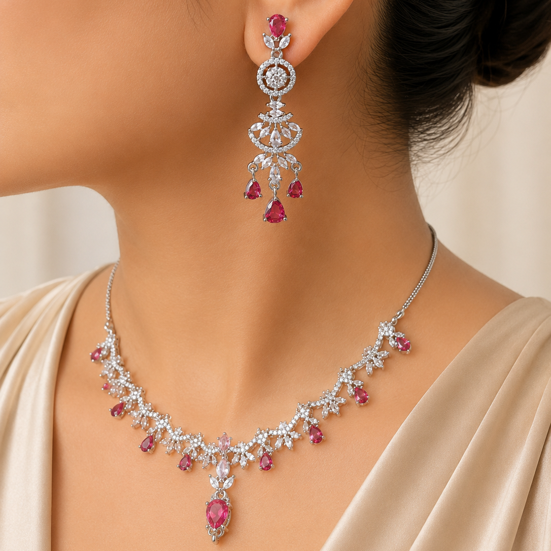 Necklace and earrings with pink gemstones on a neutral background