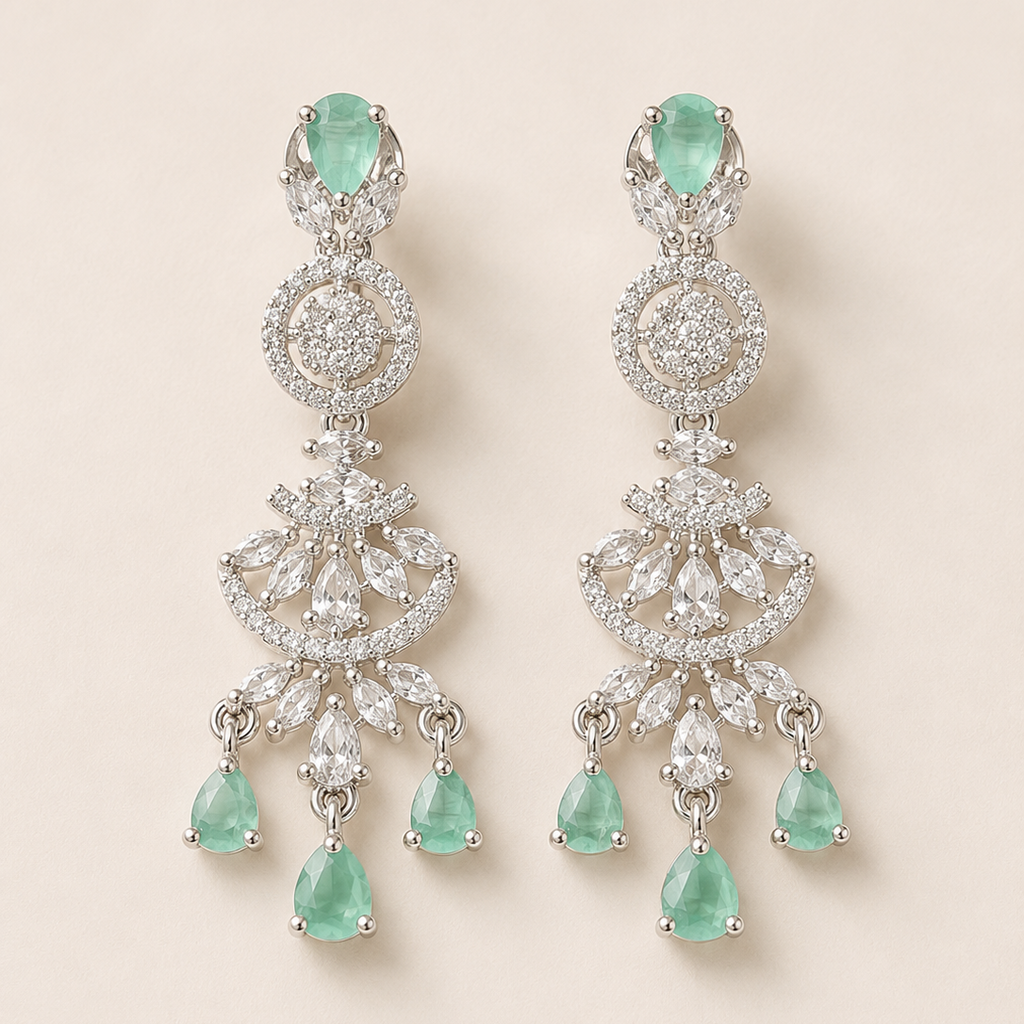 Pair of emerald and diamond earrings on a light beige background