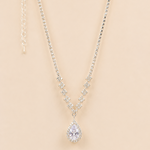 Teardrop american diamond pendant necklace on a beige background