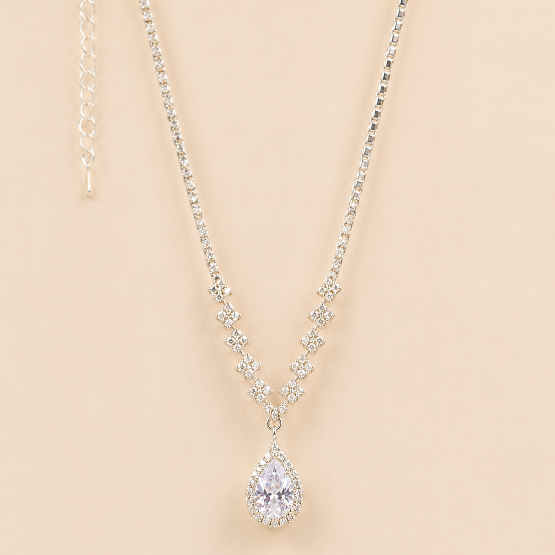 Teardrop american diamond pendant necklace on a beige background