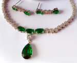 Jewelry set with green gemstones on a white surface