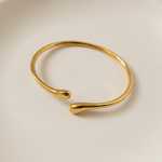 Gold tone bracelet on a light beige background