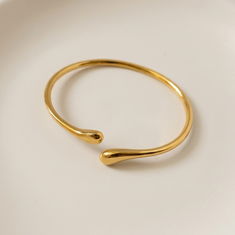 Gold tone bracelet on a light beige background