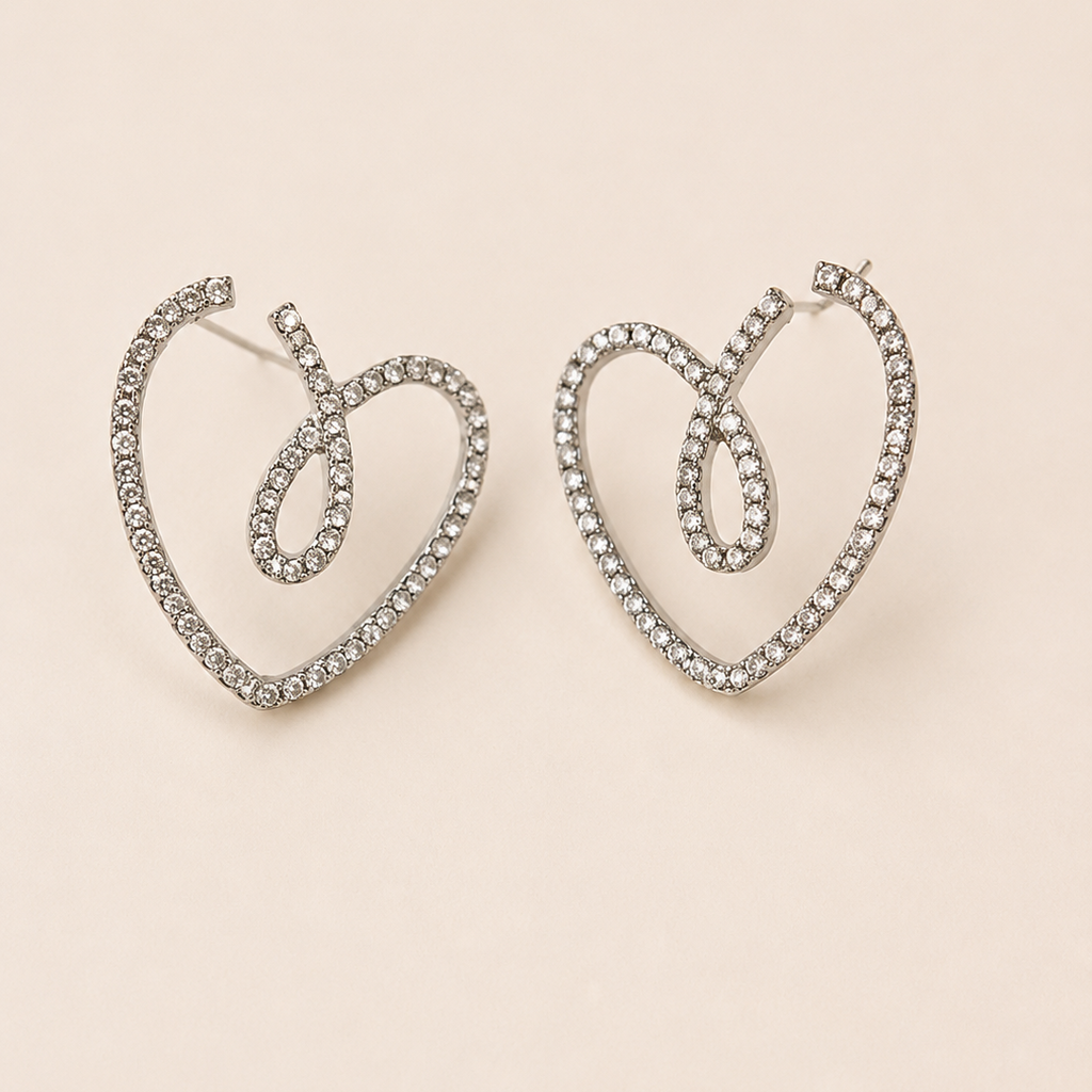Heart-shaped earrings with rhinestones on a beige background