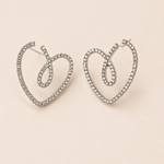Heart-shaped earrings with rhinestones on a beige background