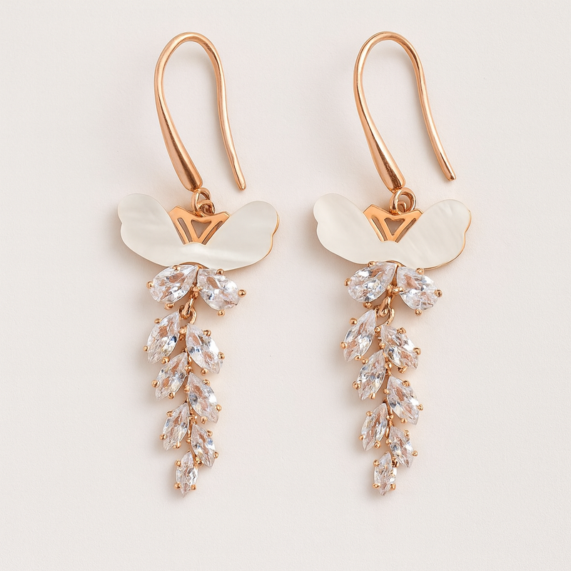 Pair of rose gold tone earrings with clear gemstones on a light background