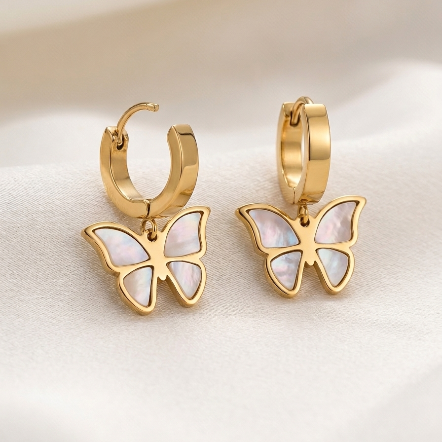 Golden butterfly earrings on a light background