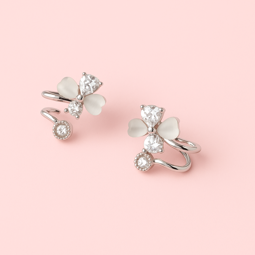 Pair of silver earrings with gemstones on a pink background