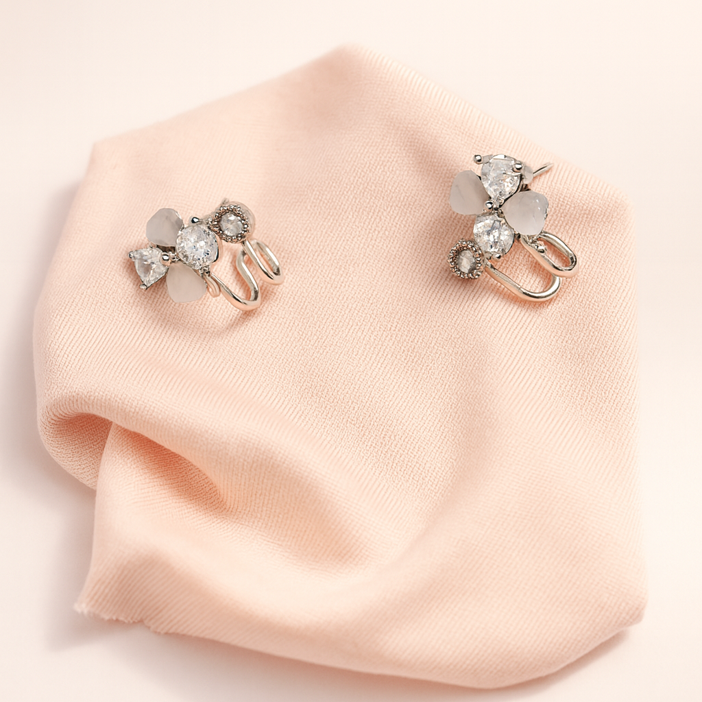 Two decorative hair clips on a pink fabric background