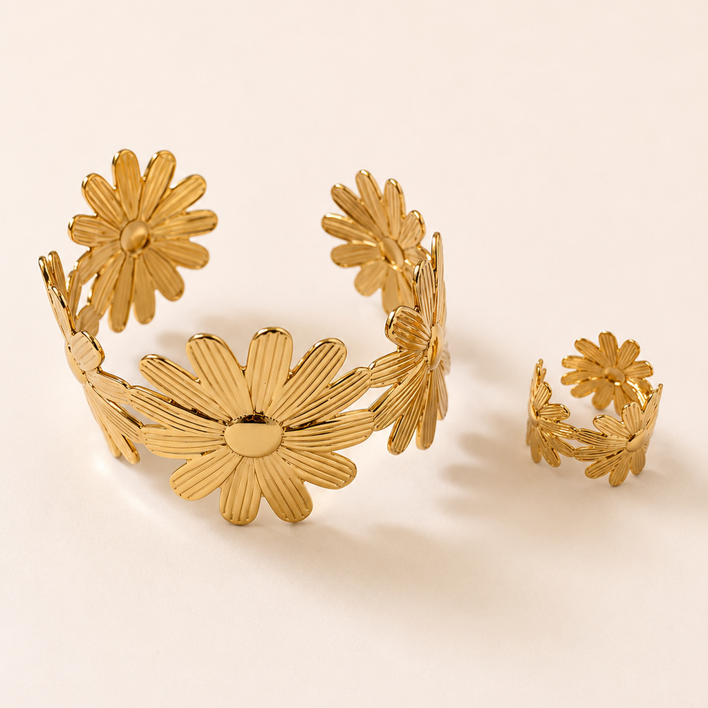 Gold tone floral bracelet and ring set on a beige background
