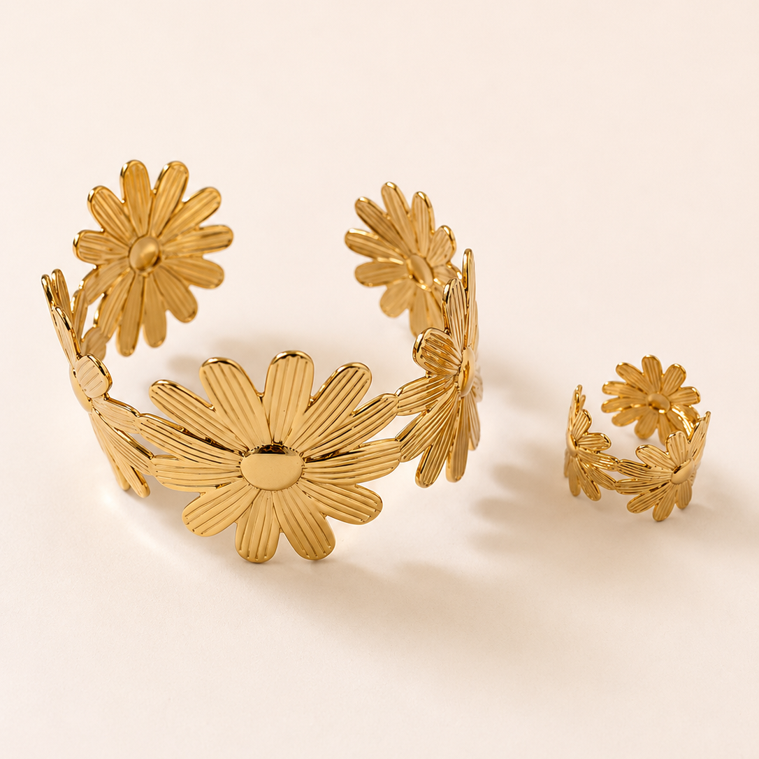 Gold tone floral bracelet and ring set on a beige background
