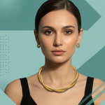 Woman wearing a goldtone necklace and earrings against a geometric patterned background