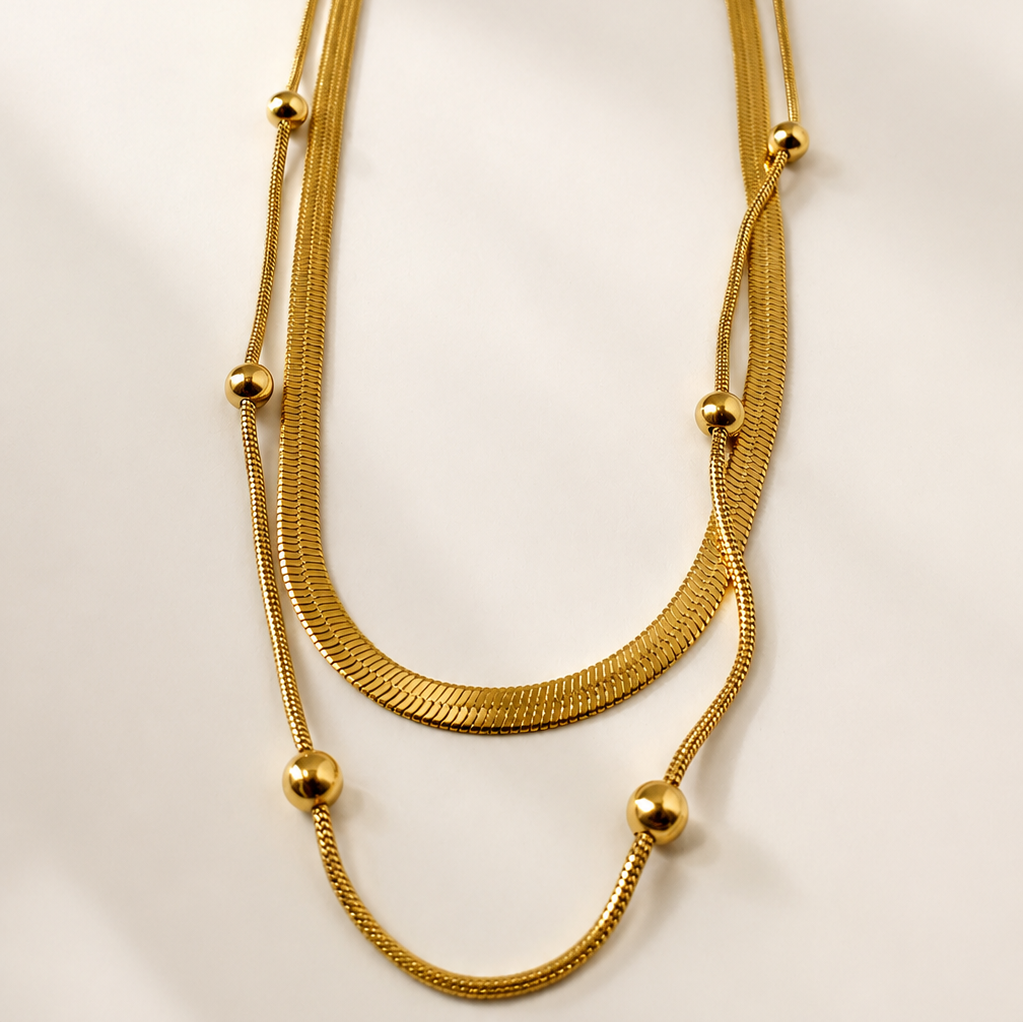 Gold tone necklace on a light beige background