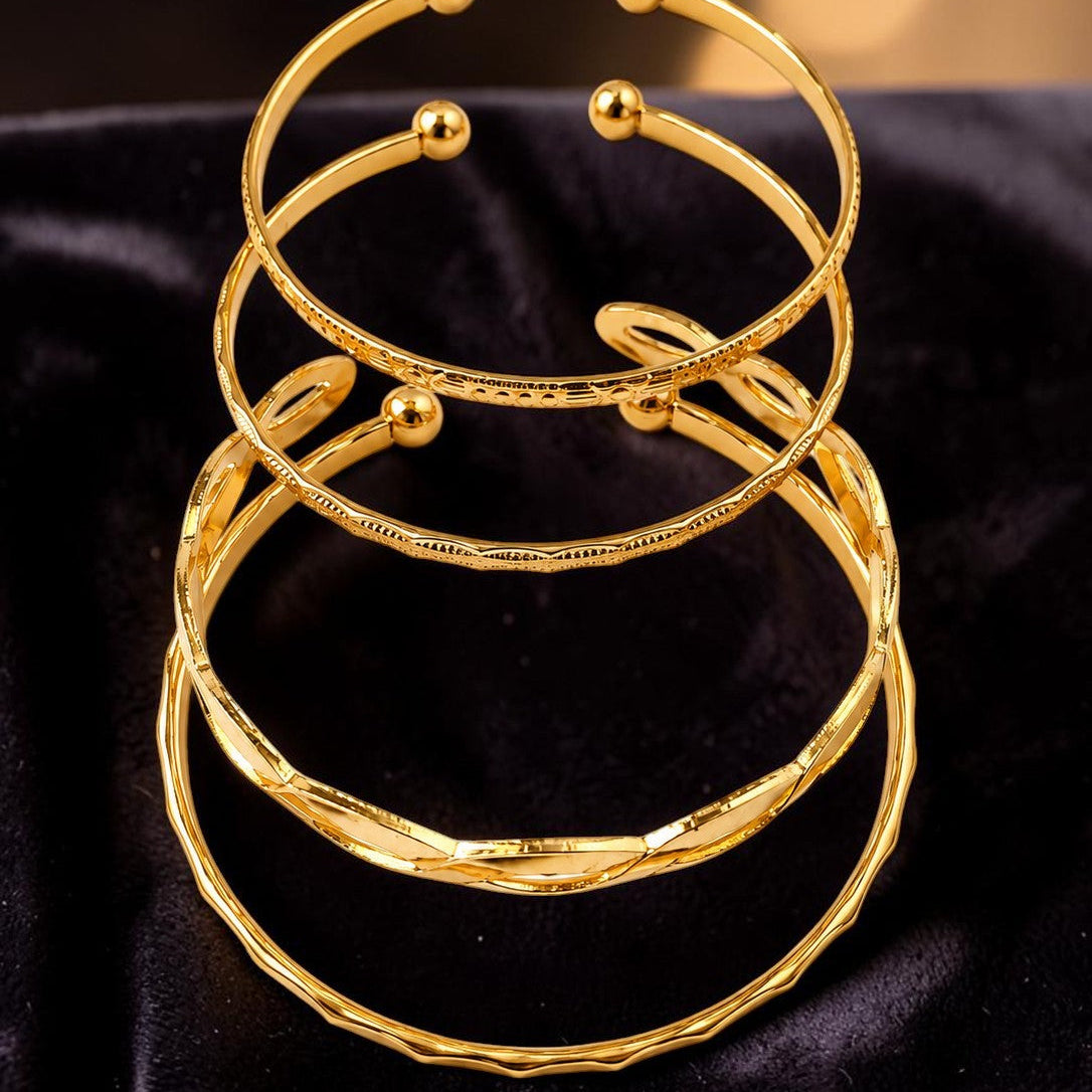 Set of golden bangles on a black background