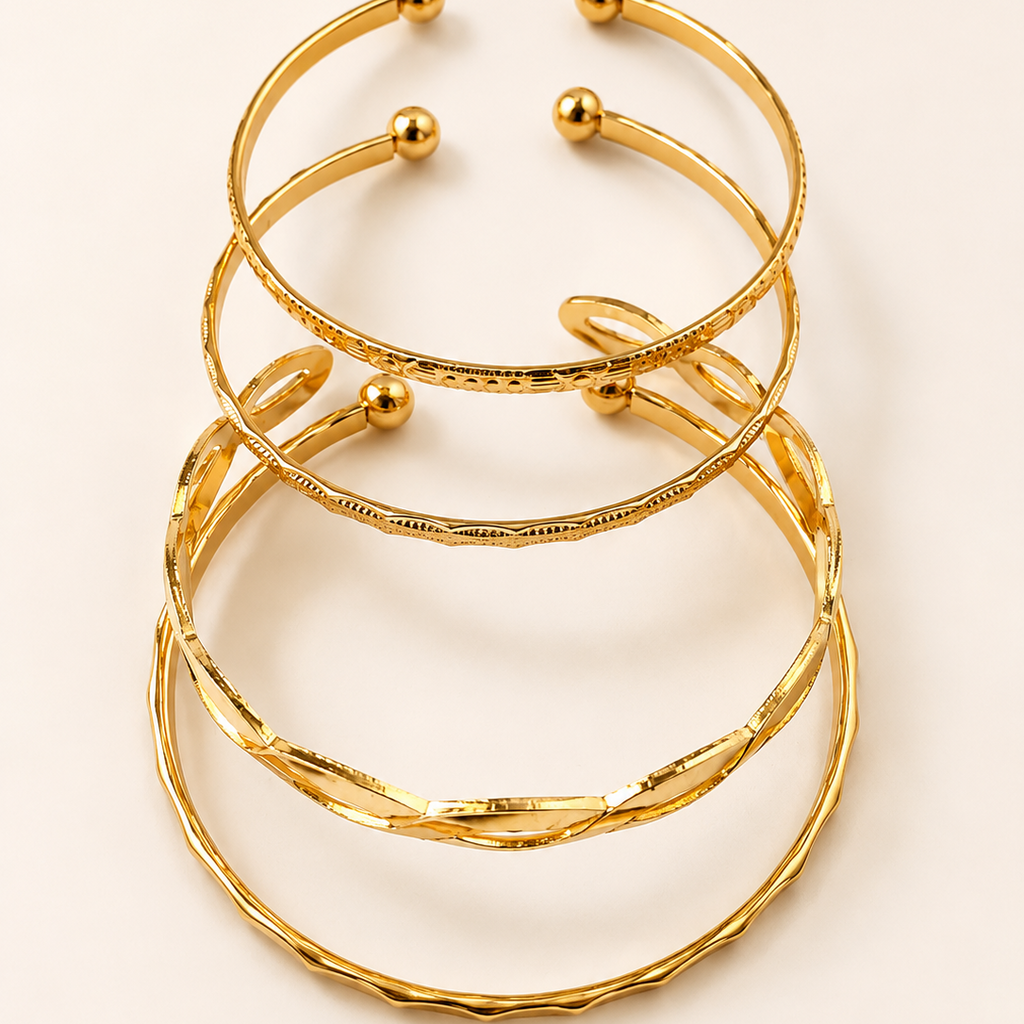 Stack of golden bracelets on a light beige background