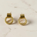 Gold hoop earrings on a marble surface