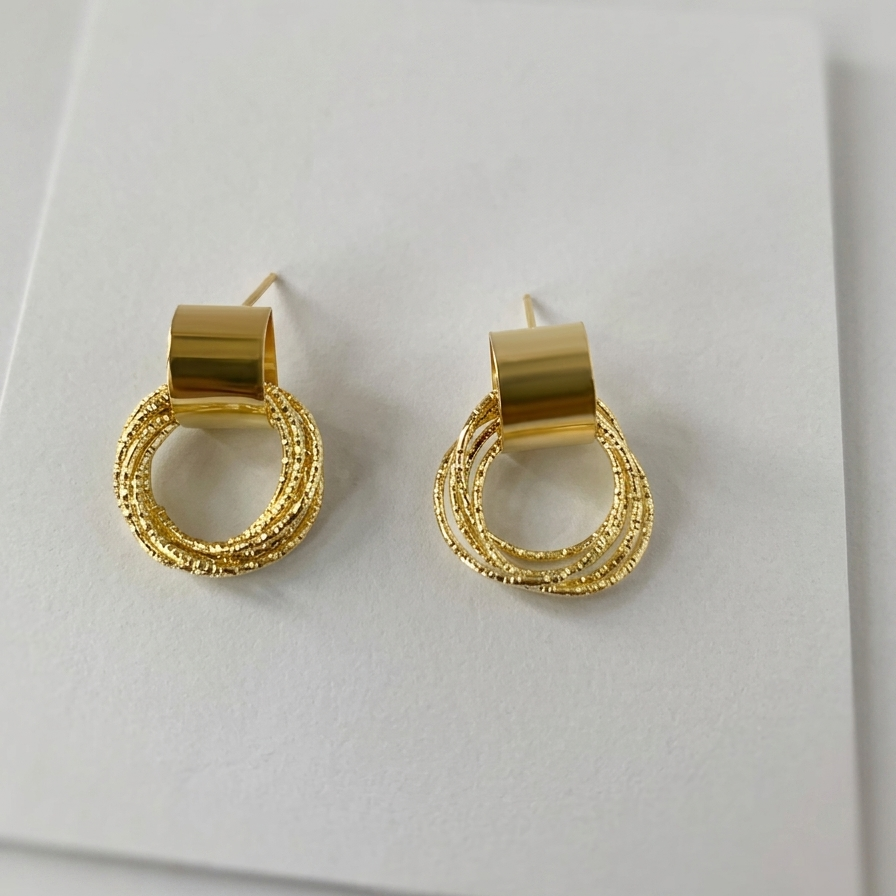 Gold hoop earrings on a white surface