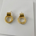 Gold hoop earrings on a white surface