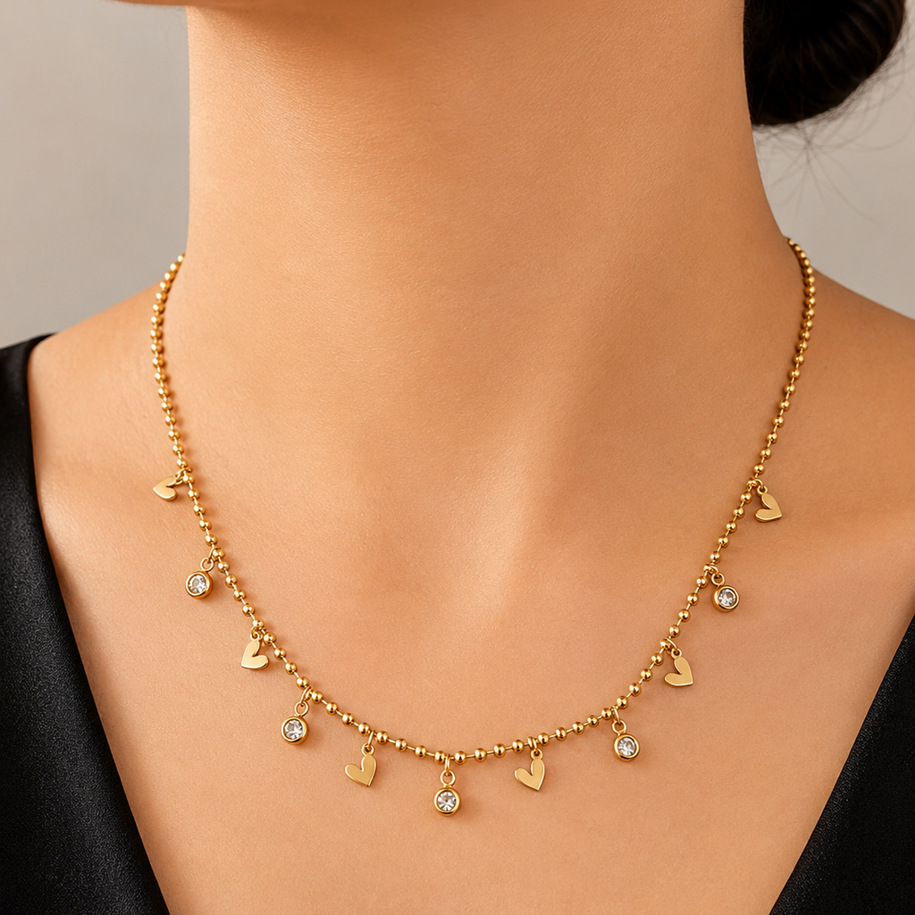 Gold tone necklace with heart-shaped pendants on a mannequin against a neutral background