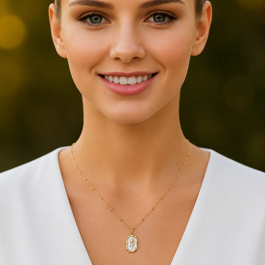 Woman wearing a gold tone necklace with a pendant against a blurred green background